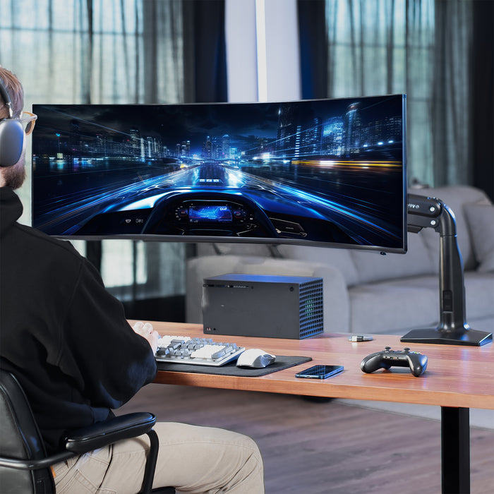 Person playing a racing game on a large monitor in a modern living room.