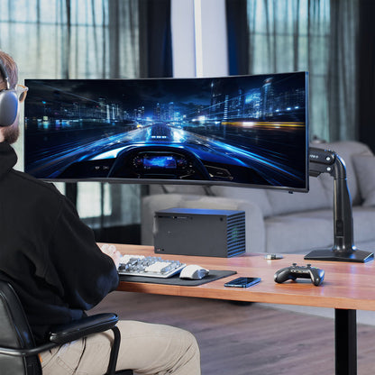 Person playing a racing game on a large monitor in a modern living room.